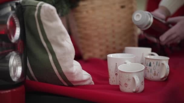 Mies kaataa kuumaa teetä kuppiin. Joulun tunnelma kotona — kuvapankkivideo