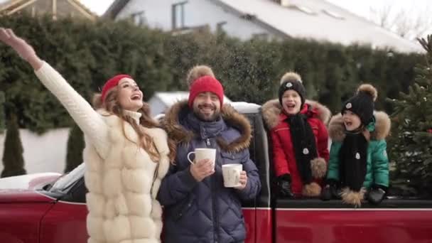 야외에서 아이들 과 함께 빨간 차 근처에서 있는 행복 한 어린 부모들 — 비디오