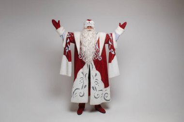 Noel Baba, gri arka planda fotokopi alanı olan yaşlı, gri sakallı adam Noel 'i kutluyor.