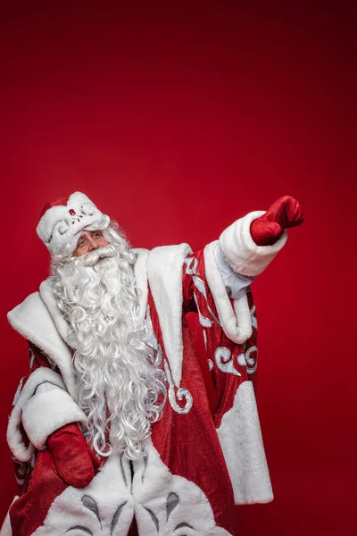 Papai Noel em traje facny apontando para longe com o braço. — Fotografia de Stock