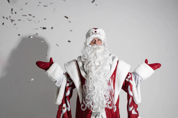 Father frost in long warm coat, red mittens and a hat celebrates new year — Stock Photo, Image