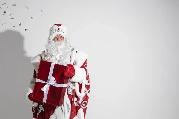 Papai Noel com presente de xmas vermelho posando em estúdio, homem idoso com presente de Natal, espaço de cópia para publicidade de férias — Fotografia de Stock