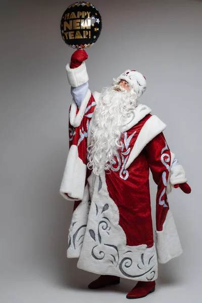 Kerstman poseren met feestelijke ballon op grijze studio achtergrond, Kerstmis en nieuwjaar viering concept — Stockfoto