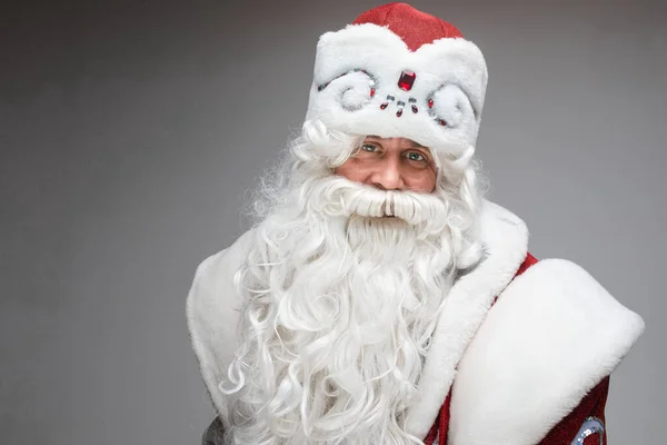 Fröhlich freundliche Weihnachtsmann posiert auf grauem Studiohintergrund mit Kopierraum für Urlaub Weihnachten und Neujahr Werbung — Stockfoto