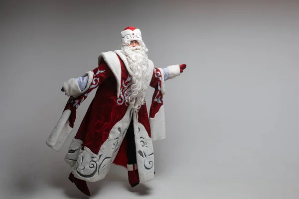 Papai Noel em movimento pulando em fundo cinza. — Fotografia de Stock