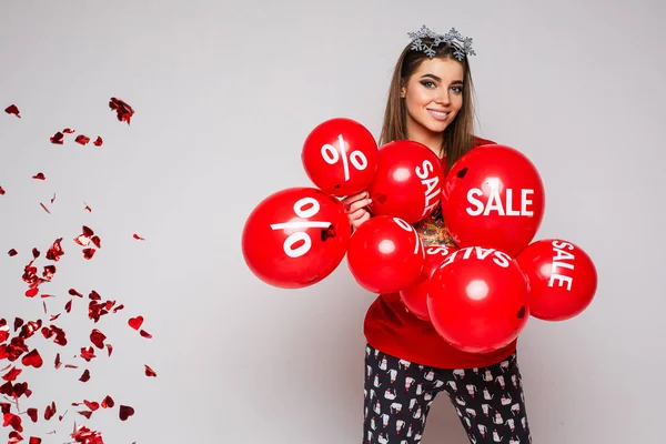 Όμορφη λευκή γυναίκα με πολλά κόκκινα μπαλόνια με πωλήσεις και ποσοστά πάνω τους. — Φωτογραφία Αρχείου