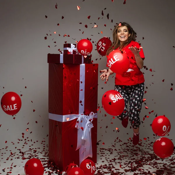 붉은 선물과 풍선을 들고 콘 페티 밑에서 뛰고 있는 소녀를 축하하는 모습, 휴일 할인, 컨셉트 — 스톡 사진