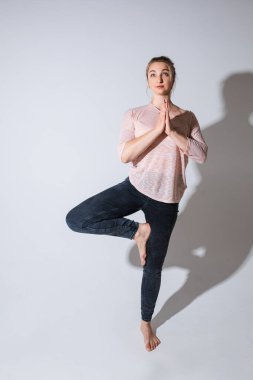 Beyaz arka plan üzerinde meditasyon yapan barışçıl beyaz kadın.