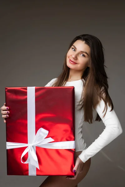 Leende söt dam poserar med röd låda med vit gåva band — Stockfoto