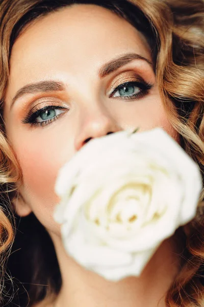 Πανέμορφη γυναίκα με τριαντάφυλλο σε κοντινό πλάνο κρατώντας ένα εύθραυστο λευκό τριαντάφυλλο μπουμπούκι και κοιτάζοντας κάμερα σε κοντινό πλάνο.. — Φωτογραφία Αρχείου