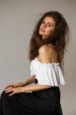 Elleri dizinde oturan bir kadın.