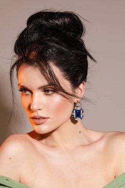 Güzel genç bayan tasarım mücevherlerini sergiliyor.