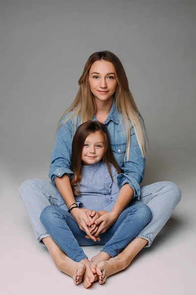 Attraktiv mamma med dotter sittande på golvet. — Stockfoto