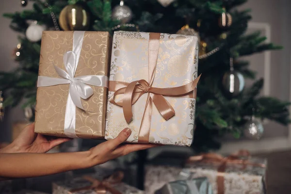 Fina presenter med band nära en härlig julgran — Stockfoto