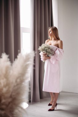 Çiçeklerle poz veren genç bayan.