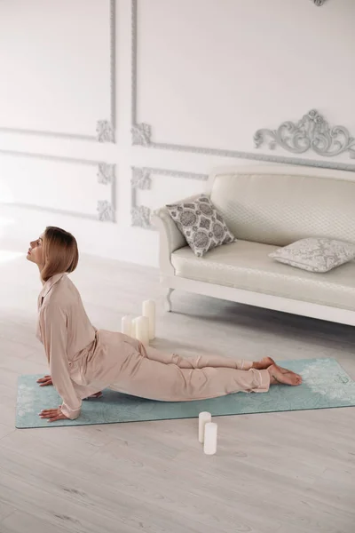 Junge Frau beginnt Morgen mit Yoga-Übungen im Schlafzimmer — Stockfoto