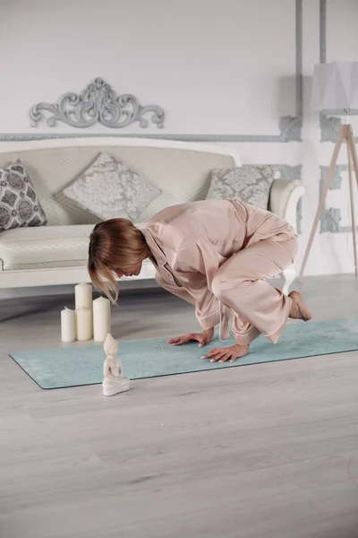 Jongedame doet gymnastiek op de vloer thuis — Stockfoto