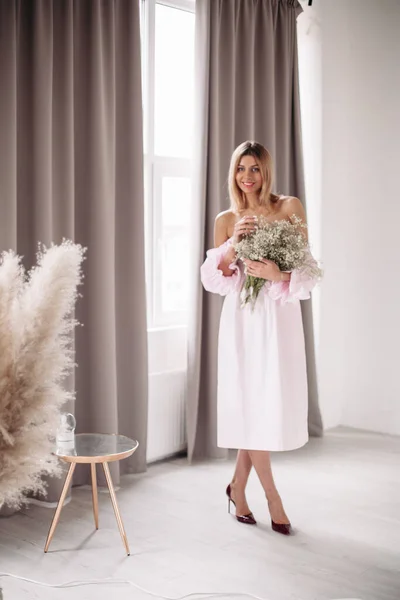 Sorridente giovane femmina in abito godendo la giornata con i fiori — Foto Stock