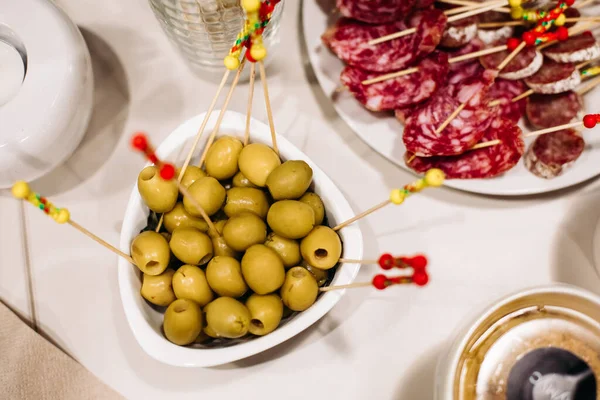 Catering, close up top view of festive appetizing olives, sausage slices, healthy snacks on banquet table, party dining — Stock Photo, Image