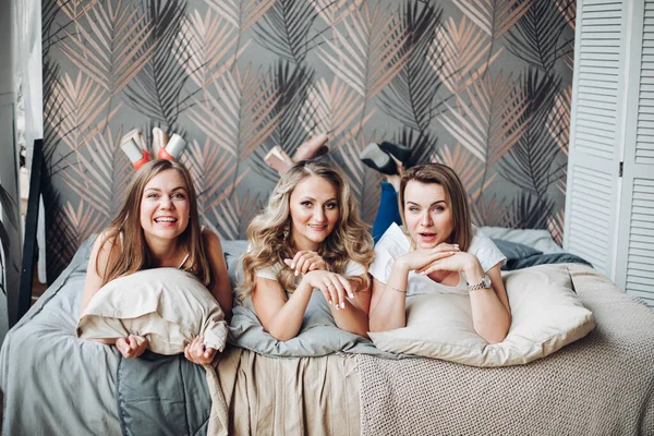 Alegre niñas se encuentra en su cama, disfruta de su vida y sonríe — Foto de Stock