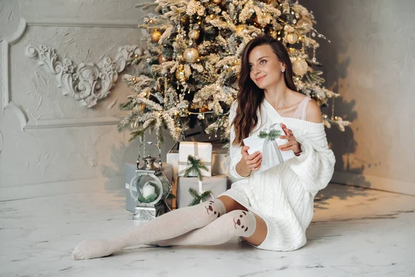 Pretty woman holding Christmas gifts near decorated tree — Stock Photo, Image