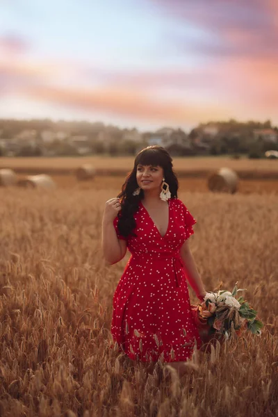 Bild einer schönen jungen Frau, die abends auf einem großen Feld mit Blumen spaziert — Stockfoto