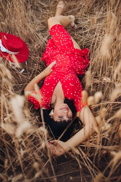 Šťastná krásná dáma odpočívající na zlaté pšenici — Stock fotografie