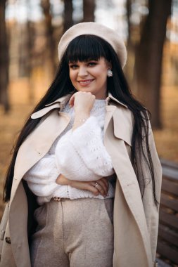 Çekici bir kadının resmi sonbahar parkına doğru yürüyor ve hayatının tadını çıkarıyor.