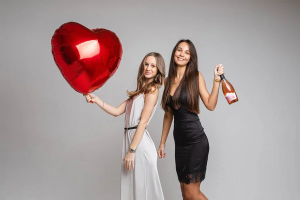 Dois amigos com cabelo castanho em belos vestidos celebram o ano novo com champanhe — Fotografia de Stock