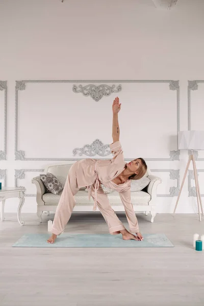 Hübsche junge Frau praktiziert zu Hause Yoga — Stockfoto