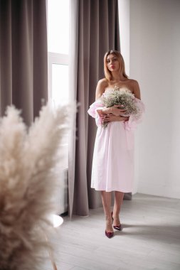 Çiçeklerle poz veren genç bayan.