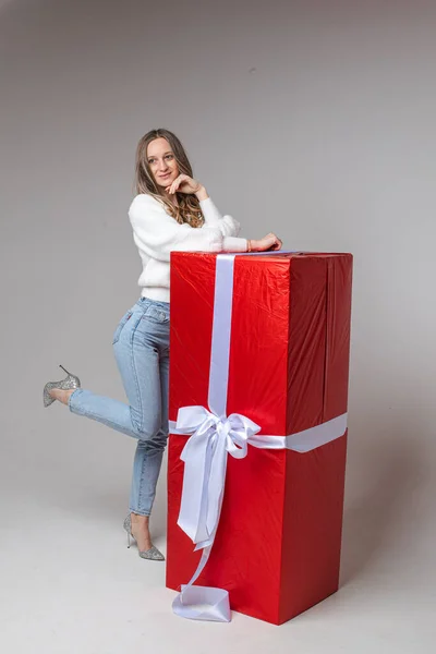 Bella modella femminile posa per la fotocamera con una grande scatola rossa con il suo regalo di Natale — Foto Stock