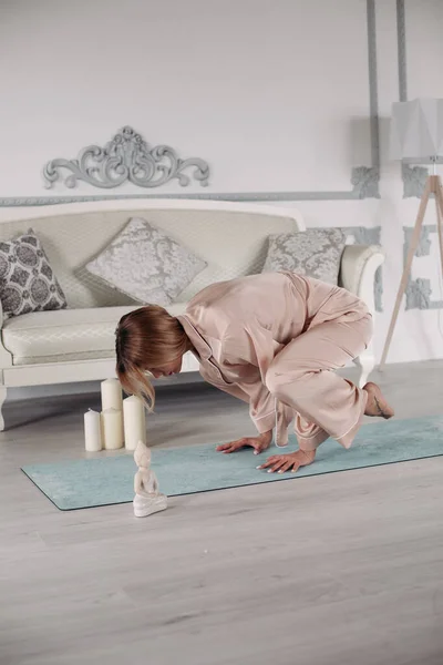 Jongedame doet gymnastiek op de vloer thuis — Stockfoto