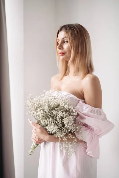 Bella ragazza in abito bianco con un boquet di fiori bianchi — Foto Stock