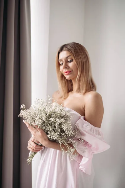 Bella giovane donna sorridente in piedi con un mazzo di fiori — Foto Stock