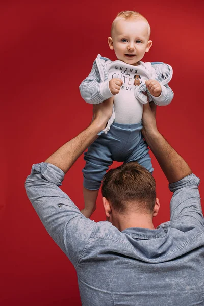 Studio porträtt av söt pojke i fäder armar. — Stockfoto