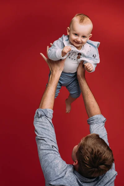 Stilig far håller sitt barn på sina händer — Stockfoto