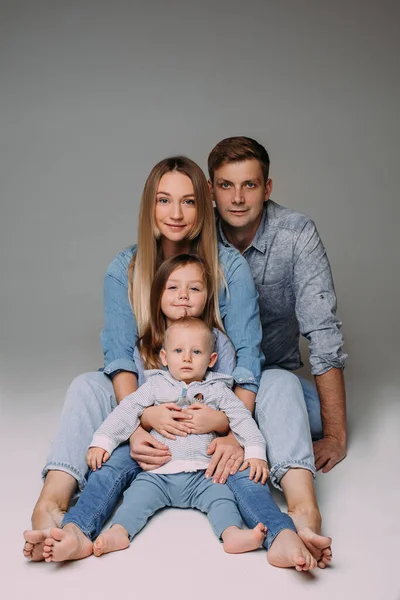 Familj på fyra poserar i denim klädkod — Stockfoto