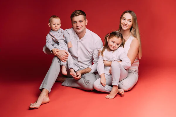 Família feliz de quatro se alegram juntos no estúdio — Fotografia de Stock