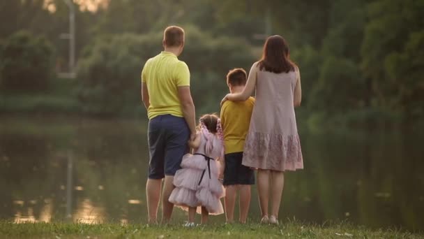 Gente en el parque. familia feliz al atardecer. Mamá, papá, hija e hijo en el parque. concepto de sueño de niño familia feliz. — Vídeos de Stock