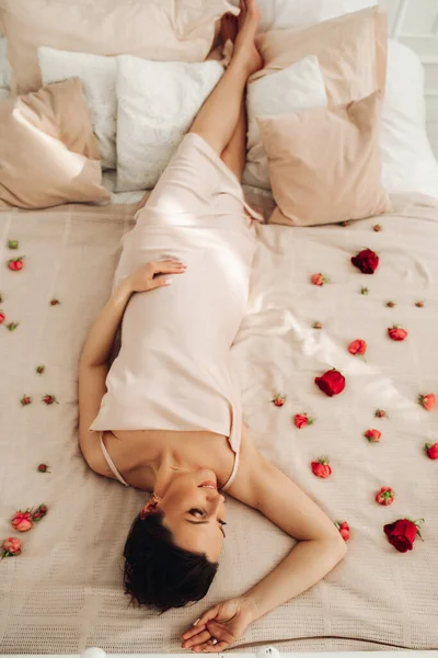 Rustige mooie dame ontspannen op een bloemrijk bed — Stockfoto