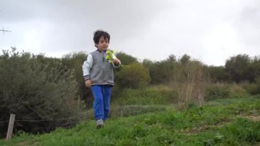 Kır çiçekleri ile genç çocuk