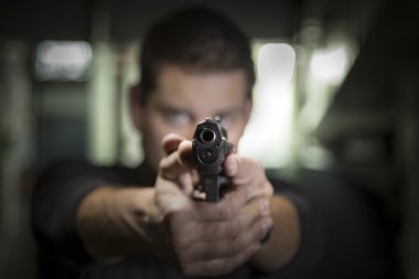 Adam kameraya bir silahı işaret