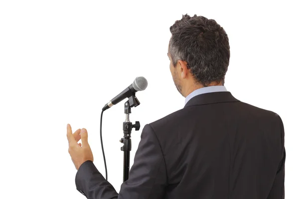 Rear view of a speaker speaking at the microphone — Stock Photo, Image