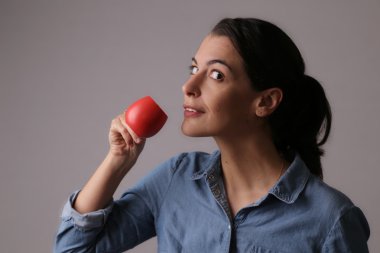 Küçük kırmızı fincandan kahve içme kadın