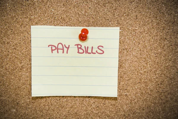 Pay bills note on a bulletin board — Stock Photo, Image