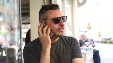 Kafede cep telefonu olan bir adam