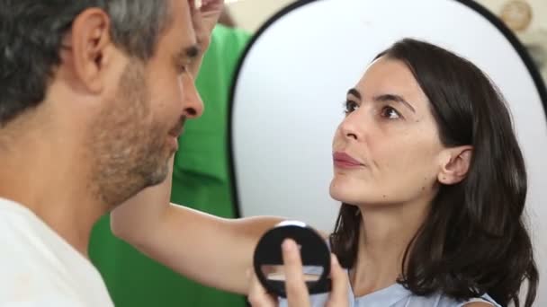 Jeune femme mis maquillage sur un gars — Video