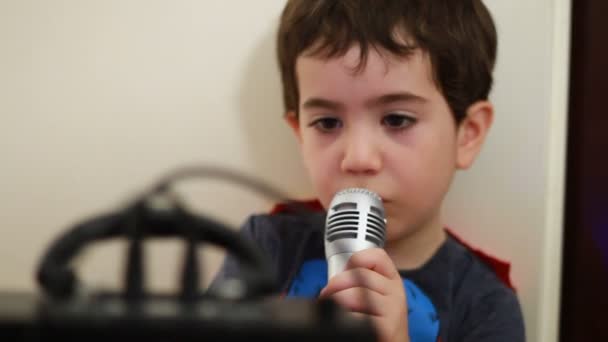 Мальчик поет под микрофон — стоковое видео