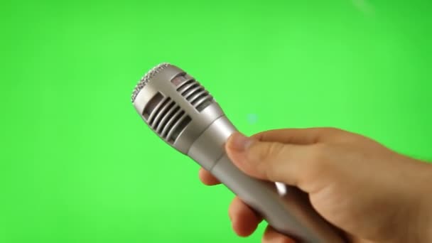 Удержание микрофона, изолированного на зеленом экране — стоковое видео